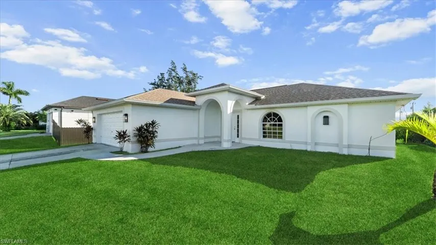 Mediterranean / spanish home featuring concrete driveway, stucco siding, an attached garage, and a front yard