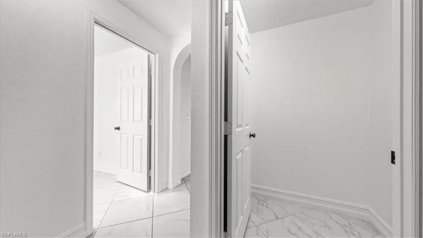 Hall with light marble finish floors and arched walkways