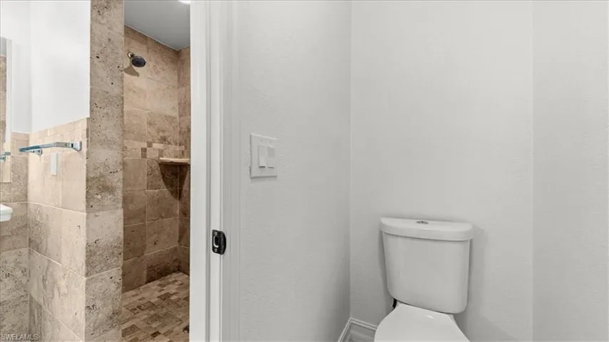 Full bath with toilet and a shower stall