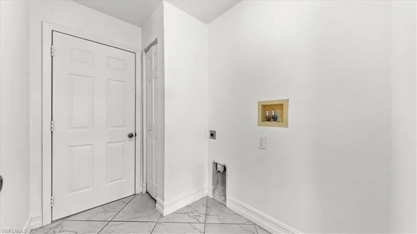 Laundry area with washer hookup, light marble finish flooring, and hookup for an electric dryer