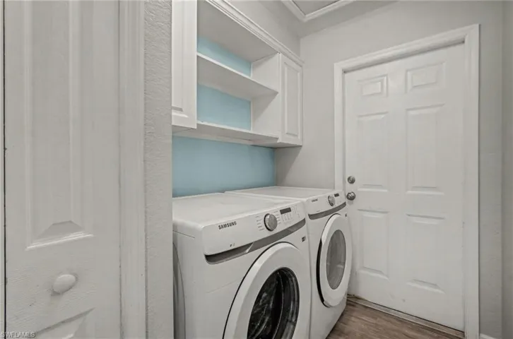 Laundry room with wood-type vinyl floors and independent washer and dryer