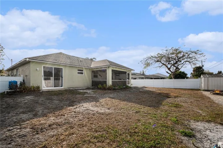Back of house with  a fenced backyard and a storage shed