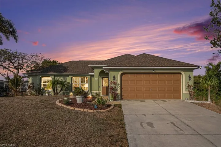 Ranch-style home featuring stucco siding, a garage, roof with shingles, and driveway