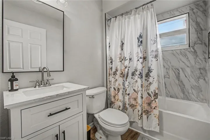 Bathroom with vanity and shower / bath combo with shower curtain