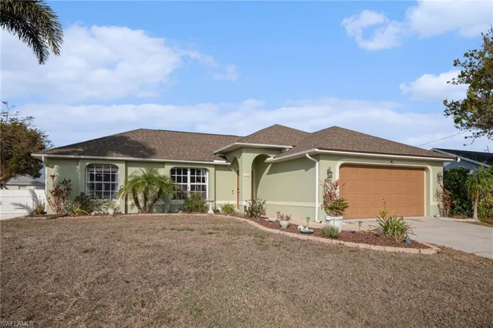 Single story home with stucco siding, an attached garage, driveway, and roof with shingles