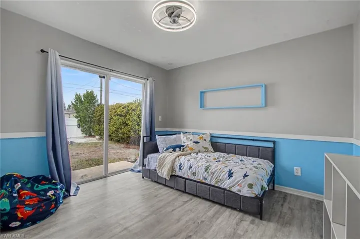 Bedroom with wood finished floors and access to outside