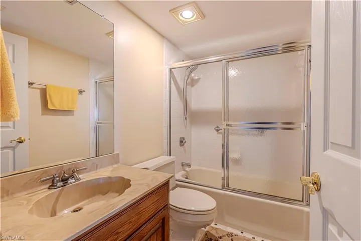 Full bath featuring vanity, toilet, recessed lighting, and combined bath / shower with glass door