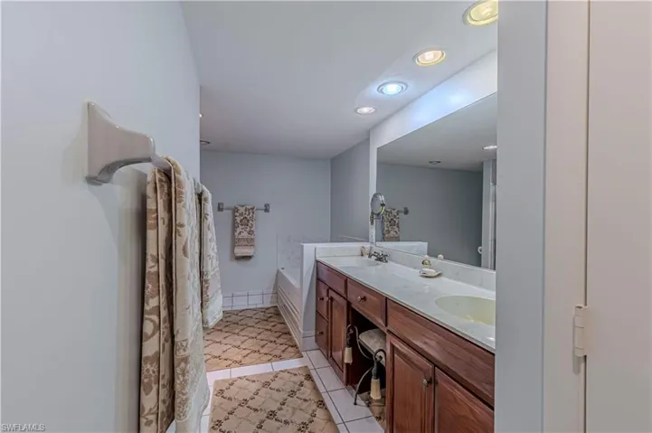 Full bathroom with tile patterned floors, recessed lighting, double vanity, and a sink