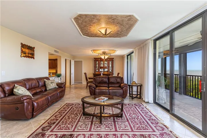 Living room with light tile patterned floors, visible vents, and expansive windows