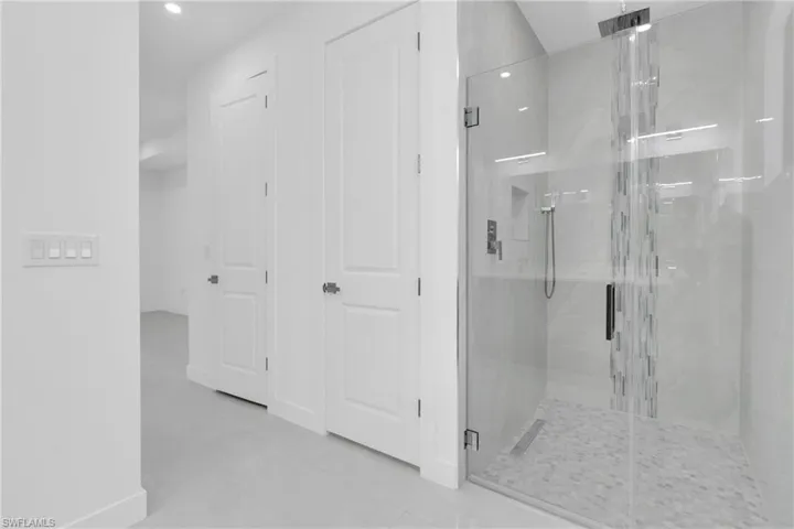 Bathroom with a shower stall, tile patterned floors, and recessed lighting