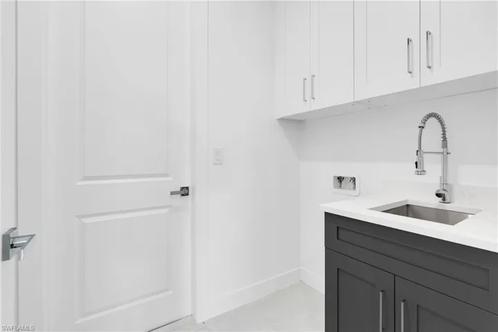 Washroom featuring hookup for a washing machine and cabinet space