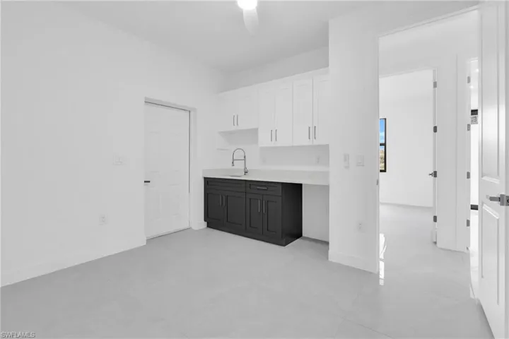 Kitchen featuring light countertops, white cabinetry, a ceiling fan, and light tile patterned floors