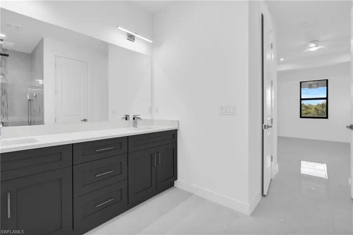 Bathroom with double vanity, a stall shower, and tile patterned flooring