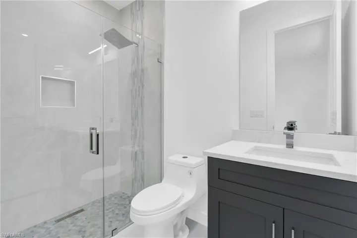 Full bath featuring vanity and a marble finish shower