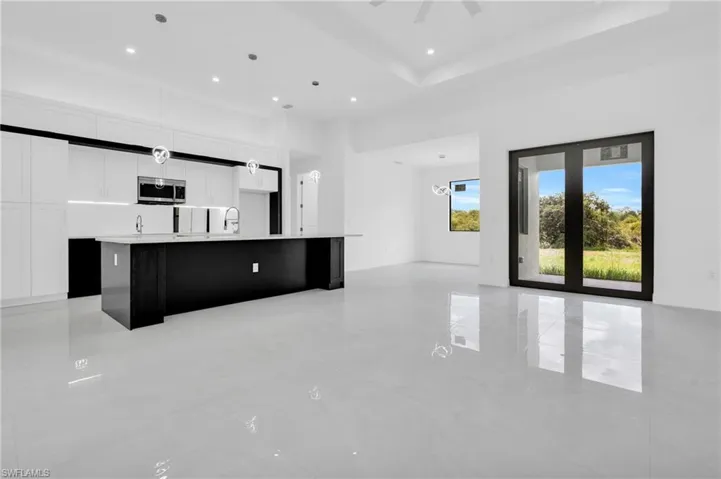 Unfurnished living room featuring a high ceiling, light tile patterned floors, recessed lighting, and a ceiling fan