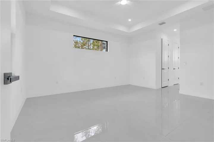 Spare room featuring ceiling fan, a raised ceiling, and recessed lighting
