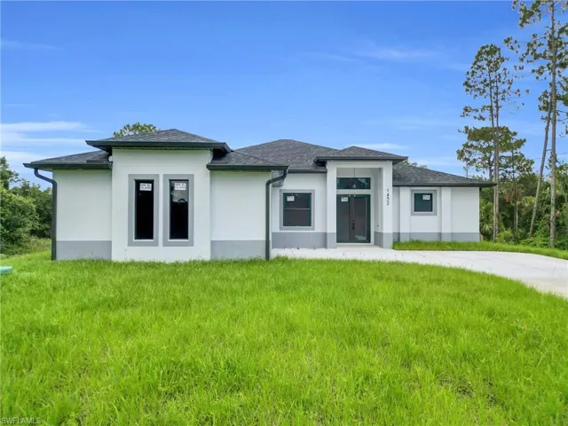Prairie-style home with stucco siding, a front lawn, and a shingled roof