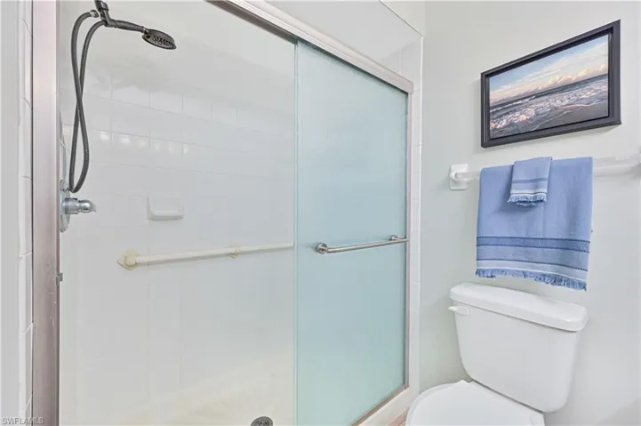 Full bath featuring a stall shower with new fixtures and sliding doors.