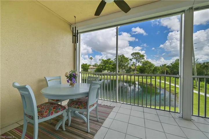 Lanai featuring a textured wall, tile patterned floors, electric shutters, and a water view