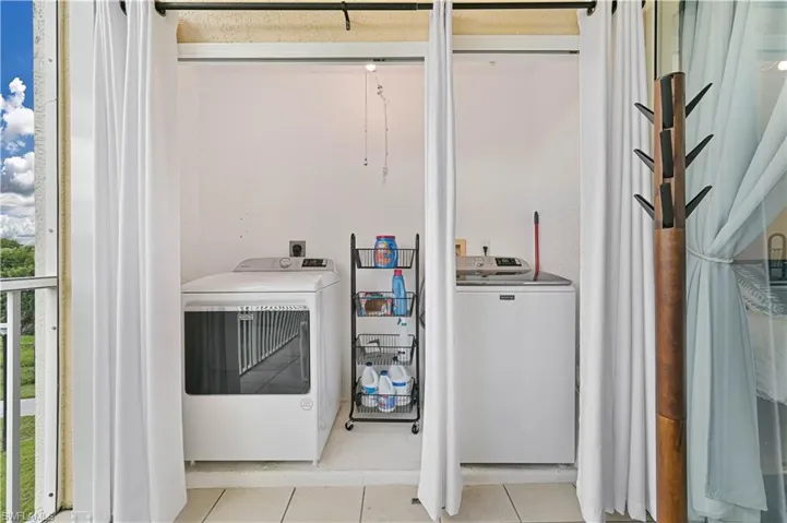 Washroom featuring tile patterned flooring and washer and clothes dryer