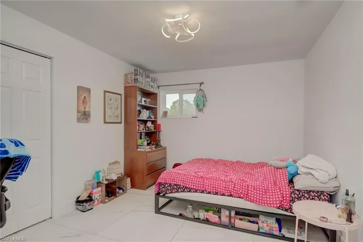 White walls featuring a contemporary ceiling light fixture and a single window