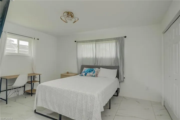 Bright interior space featuring white walls and large format tile flooring