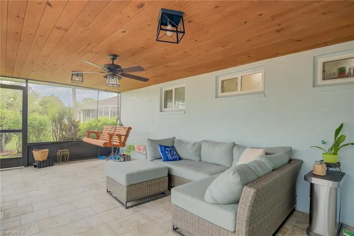 Screened patio featuring a wood-plank ceiling, ceiling fan, and tile flooring