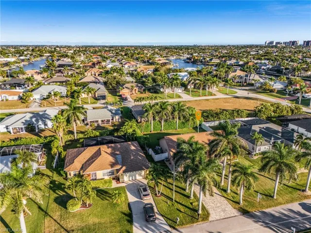 Aerial view of property and surrounding area featuring nearby suburban area and a nearby body of water