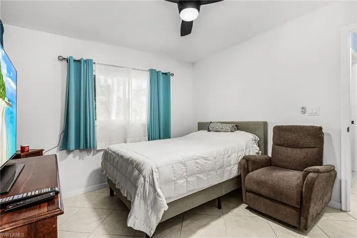 Bedroom with ceiling fan and light tile patterned flooring