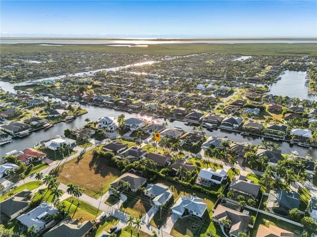 Aerial view of property and surrounding area featuring nearby suburban area
