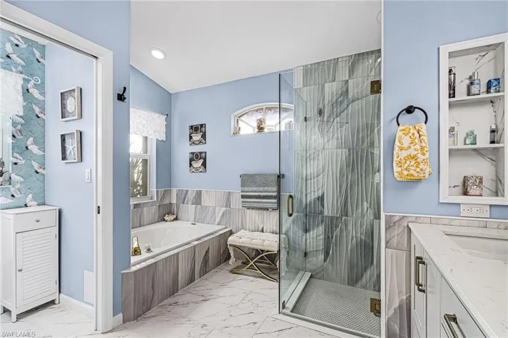 Bathroom featuring vanity, light marble finish floors, a garden tub, a stall shower, and recessed lighting