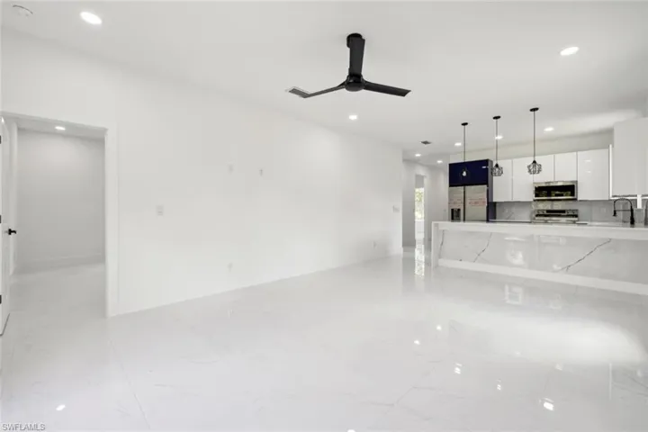 Unfurnished living room featuring sink and ceiling fan