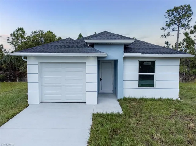 View of front of property featuring a garage and a front yard