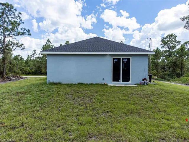 Back of house with a yard