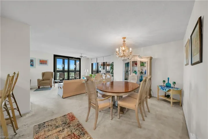 Dining room featuring a chandelier, light carpet, and a ceiling fan