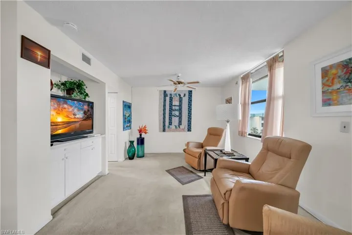 Living area featuring ceiling fan and light colored carpet