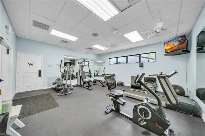 Exercise room featuring a paneled ceiling and a ceiling fan