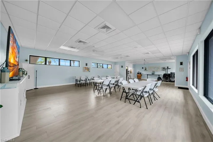 Dining room with a paneled ceiling, light wood-style flooring, and a ceiling fan