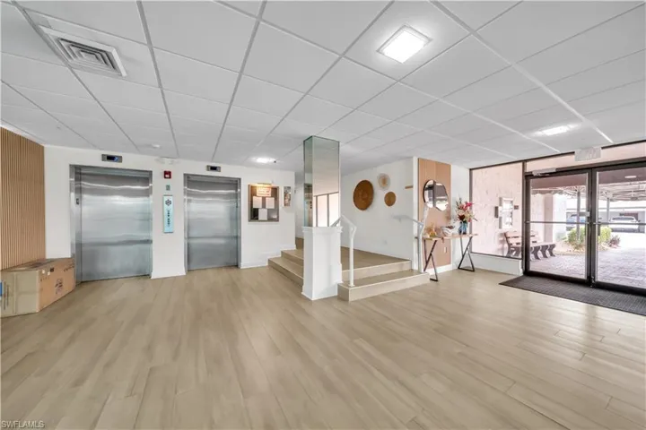 Common area featuring a paneled ceiling and stairway