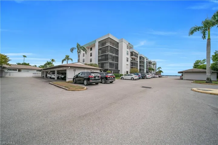 View of apartment building / complex with uncovered parking