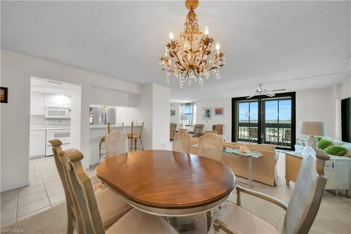 Dining room featuring a chandelier, light tile patterned flooring, and a ceiling fan