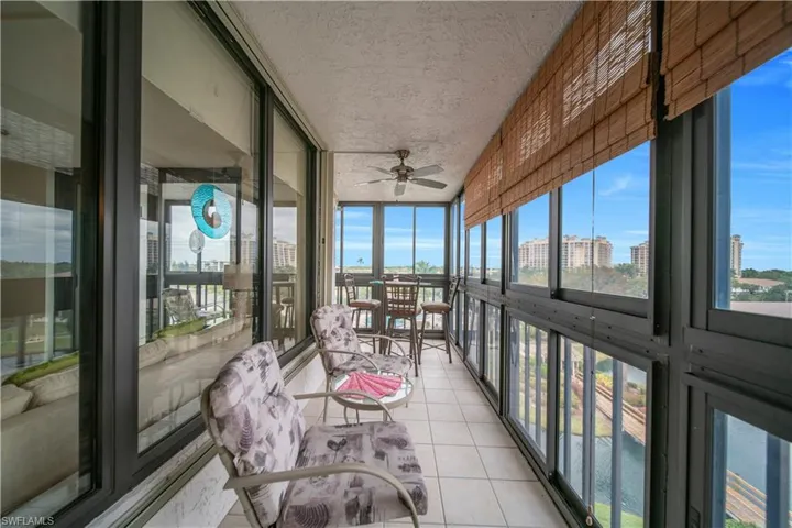 Sunroom featuring expansive windows, tile patterned floors, a textured ceiling, and a city view