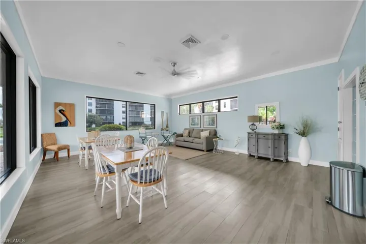 Dining area with ornamental molding, a ceiling fan, and light wood-type flooring