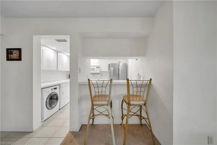 Laundry area featuring independent washer and dryer and light tile patterned floors