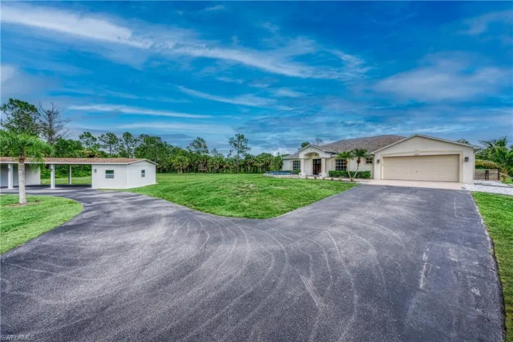 Ranch-style house with a carport, a garage, and a front yard