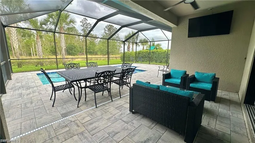 View of patio / terrace featuring ceiling fan, a lanai, and an outdoor living space