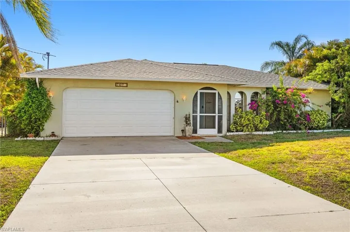 Ranch-style home with an attached garage, a front lawn, driveway, and stucco siding