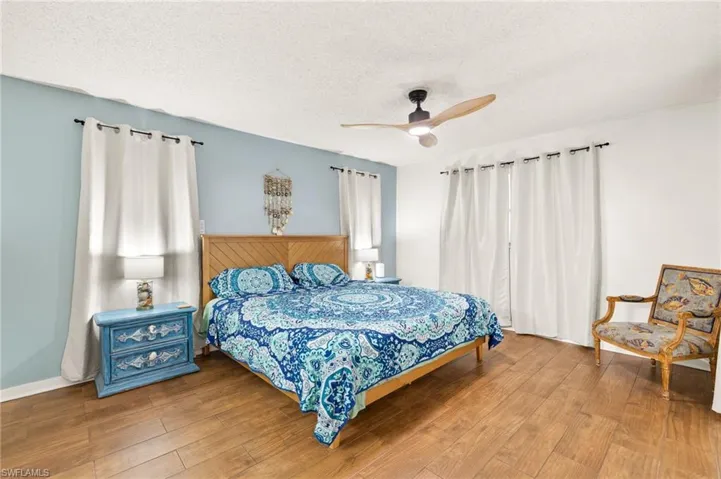 Bedroom featuring wood finished floors, a textured ceiling, and ceiling fan