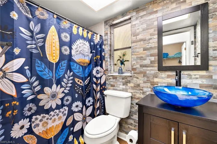 Full bath with vanity, a shower with shower curtain, and toilet