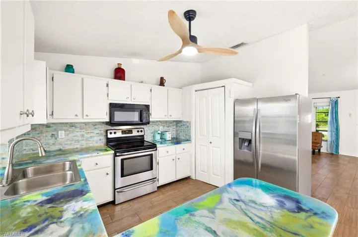 Kitchen with a sink, decorative backsplash, stainless steel appliances, and visible vents